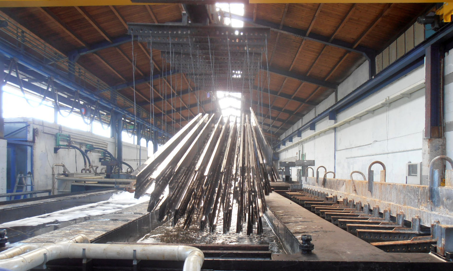 Steelwork being lowered into a molten zinc bath during hot dip galvanizing